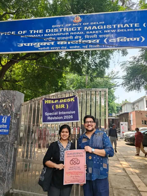 Couple holding a registration placard outside the District Magistrate office in Saket, Delhi